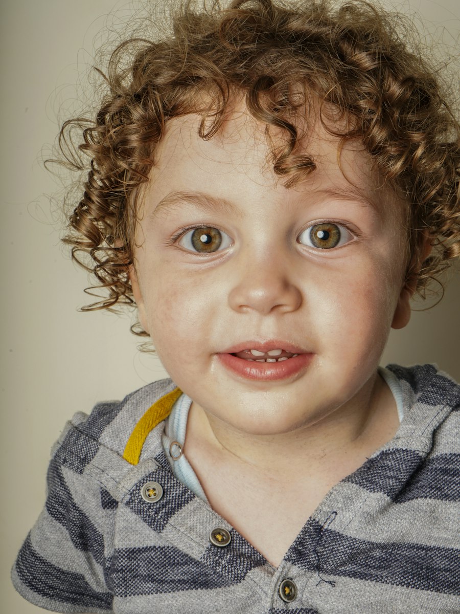 A smiling toddler boy with golden curls